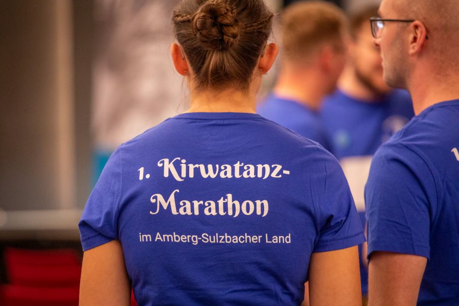 Ein Kirwamoidl trägt ein blaues Shirt, auf dem "1. Kirwatanz-Marathon" zu lesen ist.